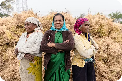 Woman farmer holding harvested crops in a field